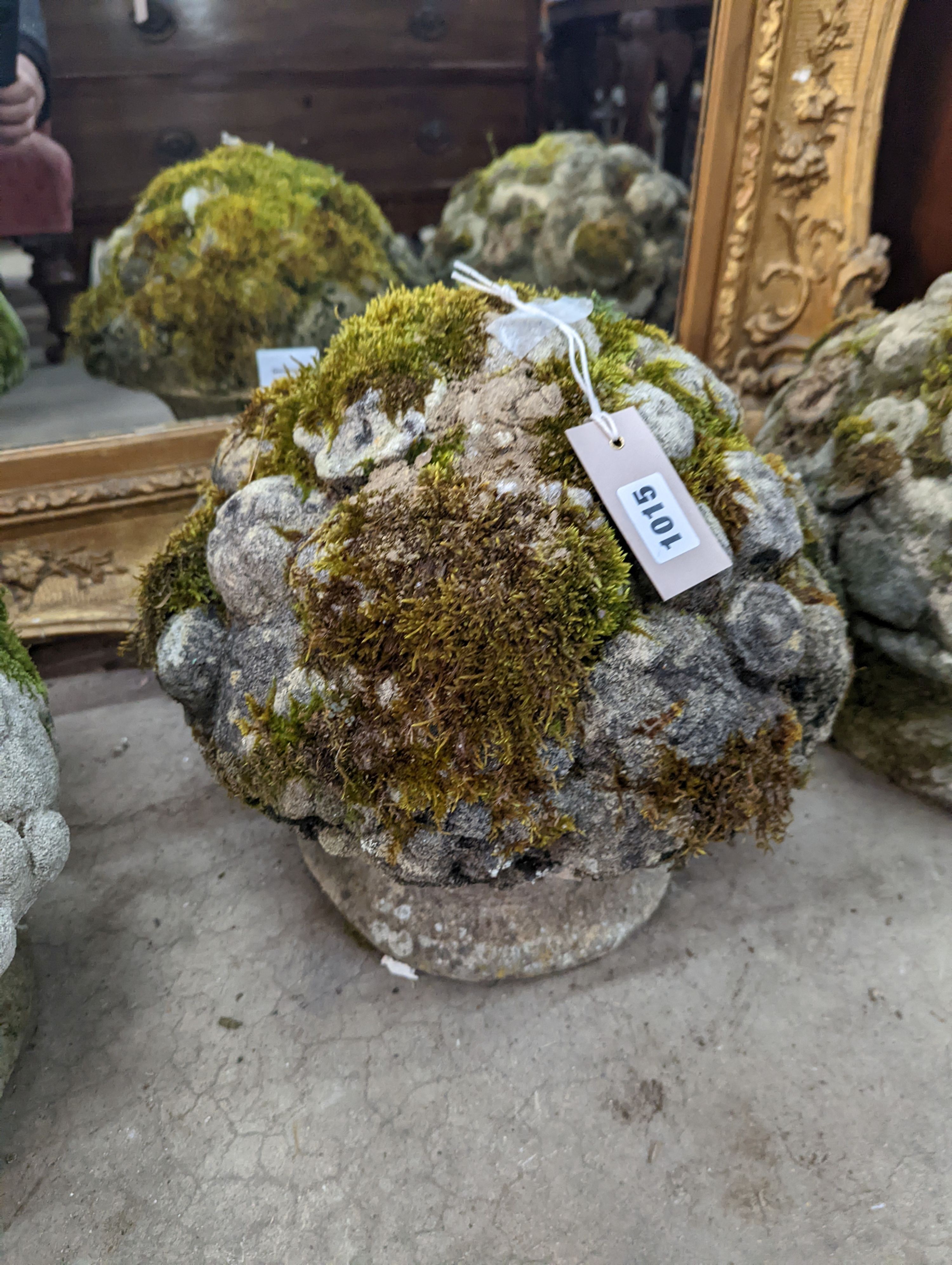 A set of three weathered reconstituted stone garden ornaments modelled as floral bunches, diameter 32cm, height 30cm